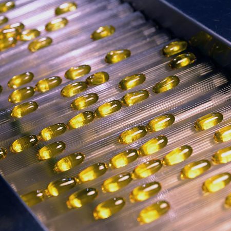 Omega-3 capsules travel down a production line at Sancilio and Company Inc.'s laboratory and manufacturing facility, in Riviera Beach, Florida, U.S., on Friday, Sept. 13, 2013. Sancilio & Company Inc. (SCI) is a biopharmaceutical company that researches, develops, manufactures and distributes generic and brand supplements, including highly concentrated Omega-3 essential fatty acids. Photographer: Mark Elias/Bloomberg via Getty Images